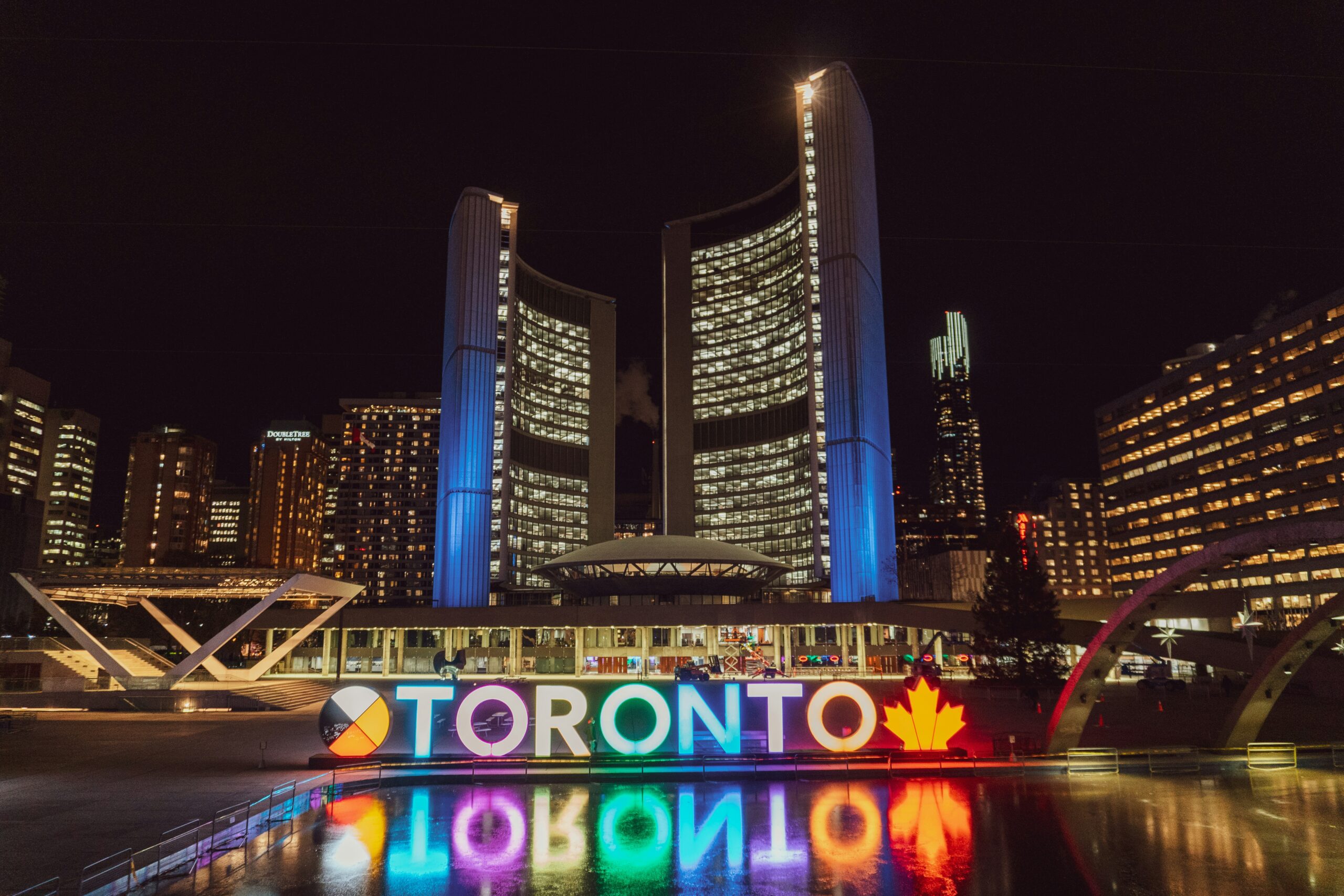 Toronto sign and Toronto City Hall at night